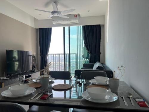 a living room with a dining room table with dishes on it at Edumetro B32 3 Bedroom Subang Sunway By MICASA GROUP in Subang Jaya