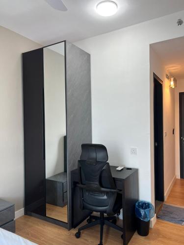 a black chair sitting at a desk next to a mirror at Edumetro B32 3 Bedroom Subang Sunway By MICASA GROUP in Subang Jaya
