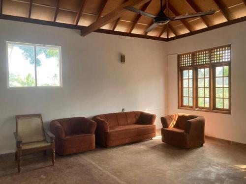 a living room with two couches and a chair at Margosa villa in Tangalle