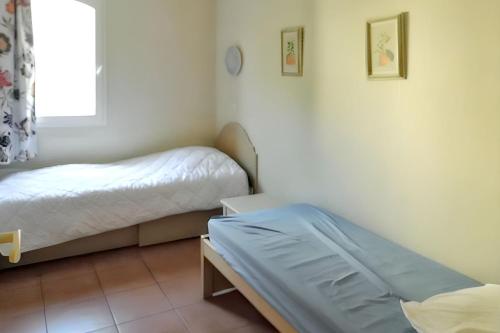 a bedroom with two beds and a window at Appartement lumineux Roquebrune 45m² avec piscine partagée in Roquebrune-sur-Argens