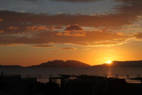 a sunset over the water with mountains in the background at Hazards View at Aqua Sands in Swansea