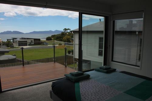 a room with a large window with a wooden deck at Hazards View at Aqua Sands in Swansea