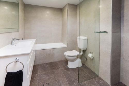 a bathroom with a toilet and a sink and a shower at Nautilos On The Harbour in Newcastle