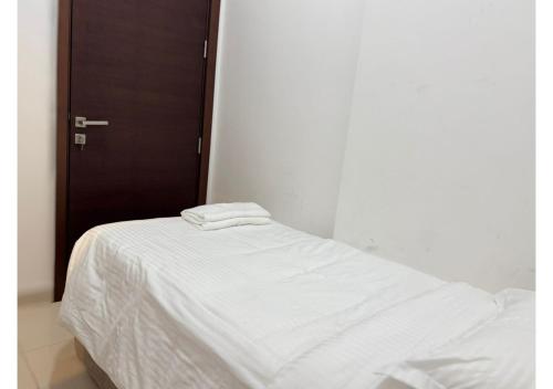 a white bed with two towels on top of it at 1 - BLUE WORLD - Al Dana Villas in Fujairah