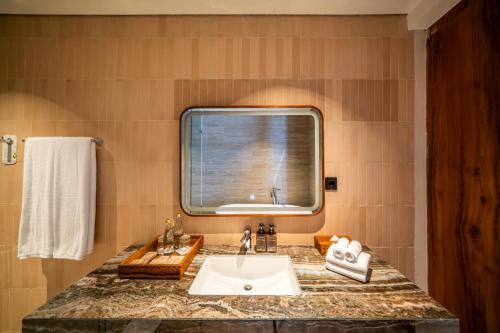 a bathroom with a sink and a window at TUI BLUE Berawa Hotel and Villas in Canggu
