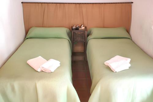 two beds sitting next to each other in a room at Charming House in Estepa with Shared Pool in Lora de Estepa