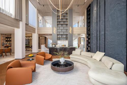a living room with a couch and chairs and a table at Taohuawu Mountain Luxury Villa Hotel in Lijiang