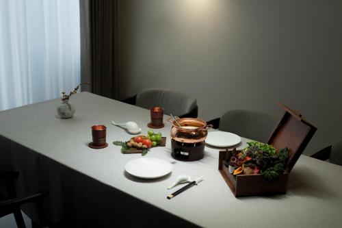 a table with plates and a basket of food on it at Taohuawu Mountain Luxury Villa Hotel in Lijiang