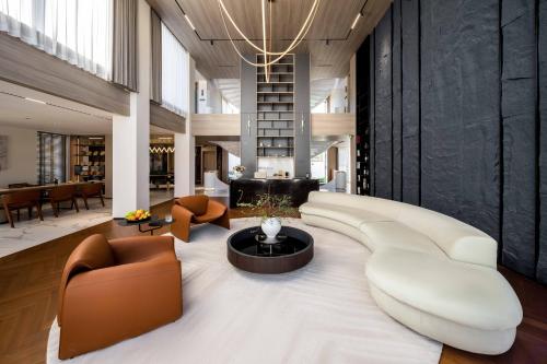 a living room with a large white couch and chairs at Taohuawu Mountain Luxury Villa Hotel in Lijiang