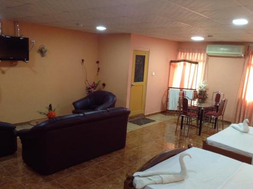 a living room with a couch and chairs and a table at Sunshine Hotel in Trincomalee