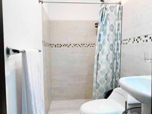 a bathroom with a shower and a toilet and a sink at Casa de 3 dormitorios, piscina privada, parqueo free in Estancia Vieja