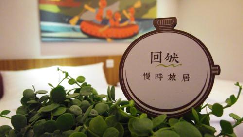 a clock sitting on top of a green plant at Meci Hotel in Hualien City