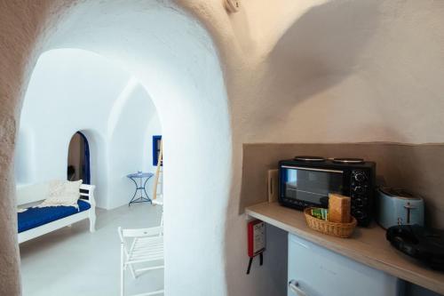 a living room with a tv on a counter at Blu Bianco Cave House by SV in Oia