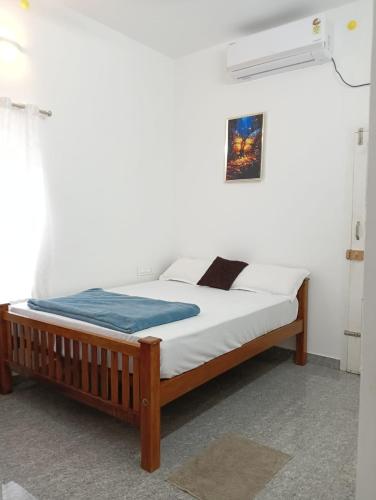 a bed in a white room with at Whitefort Family Villa Alleppy-Homestay in Alleppey