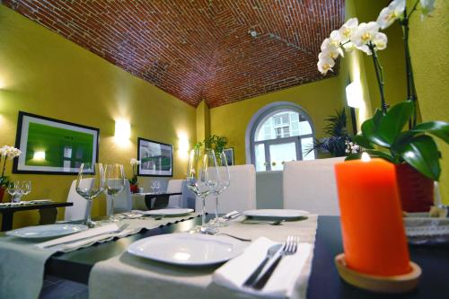a dining room with a table with an orange candle at Hotel Boutique Antiche Mura in Saluzzo