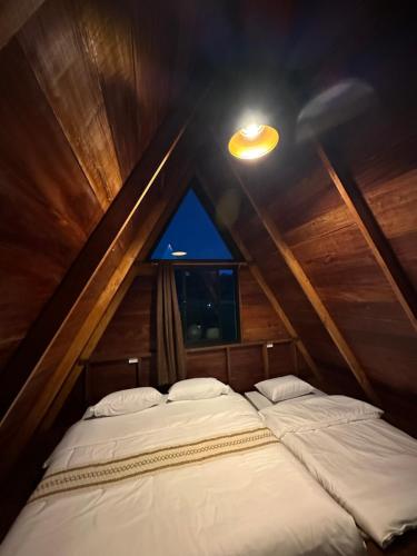 a couple of beds in a room with a window at เฮือนจินดา Jins BANN A2 in Ban Wang Masiu