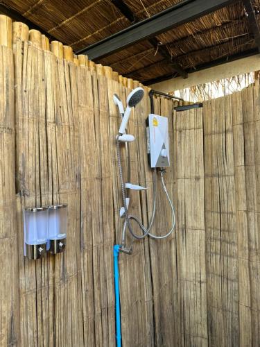a shower in a wooden wall with a shower head at เฮือนจินดา Jins BANN A2 in Ban Wang Masiu