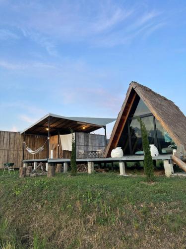 a house with a thatched roof on a field at เฮือนจินดา Jins BANN A2 in Ban Wang Masiu