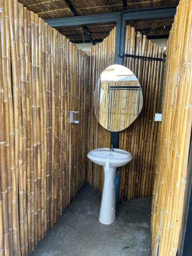 a bathroom with a sink and a mirror on a wall at เฮือนจินดา Jins BANN A2 in Ban Wang Masiu