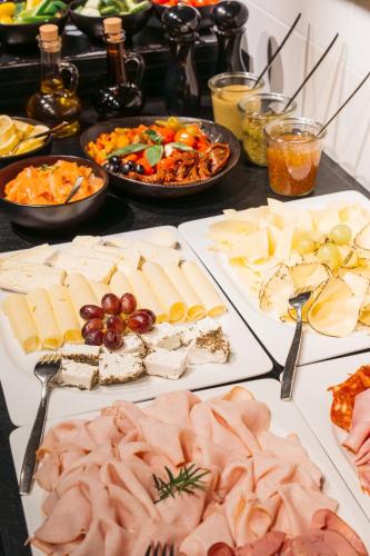 a table with many different types of meats and cheese at Ruby Sofie Hotel Vienna in Vienna