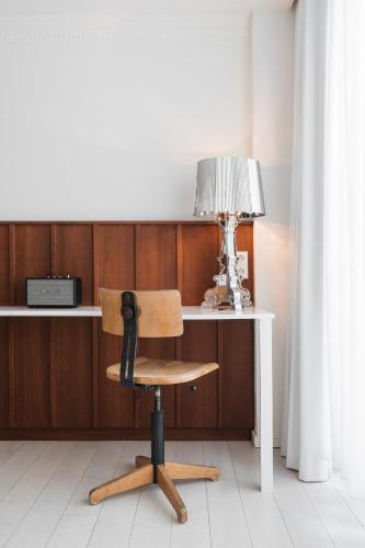 a desk with a chair and a lamp on it at Ruby Sofie Hotel Vienna in Vienna