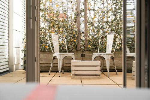 two white chairs sitting in front of a window at Ruby Sofie Hotel Vienna in Vienna