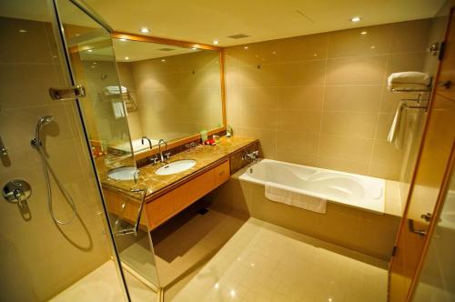 a bathroom with a tub and a sink and a shower at Hotel Kuva Chateau in Zhongli