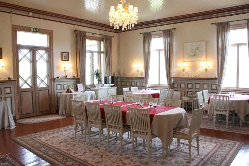 a dining room with tables and chairs and a chandelier at Woikoski Feeling - Kirjokiven Kartano in Joutsenlahti