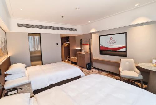 a hotel room with two beds and a flat screen tv at Hotel Landmark Canton in Guangzhou
