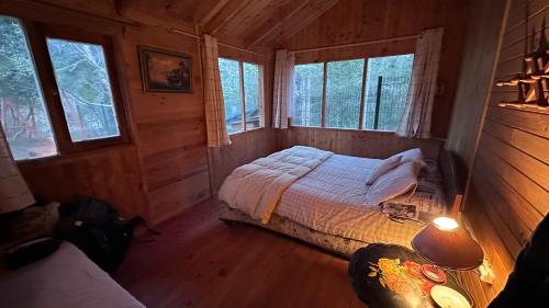 a bedroom with a bed in a log cabin at Cabaña Mawinda in Pucón