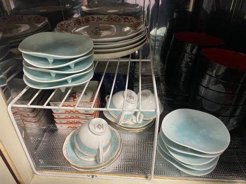 a drawer filled with plates and bowls and other dishes at 徳治郎の宿 in Izumi-Sano