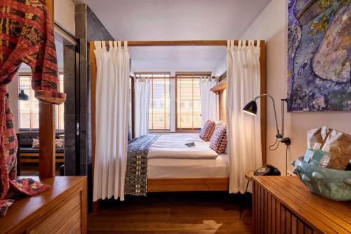 a bedroom with a bed and a window at Manon Les Suites Guldsmeden in Copenhagen