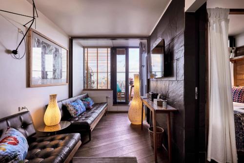 a living room with a couch and some vases at Manon Les Suites Guldsmeden in Copenhagen