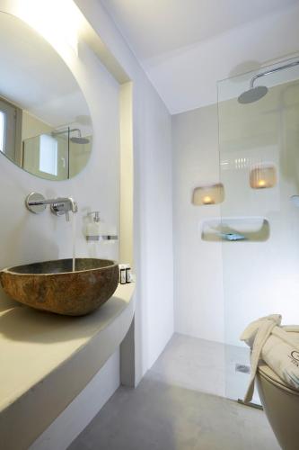 a bathroom with a stone sink and a mirror at Eolia Kamari Villa in Kamari
