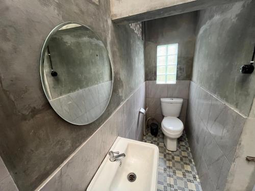 a bathroom with a sink and a mirror and a toilet at Saka Homestay Boutique & Cafe in Borobudur