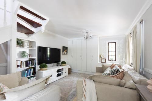 a living room with a couch and a tv at Exclusive Luxury Designer Cottage Estate for 10 - Peaceful Retreat Just 8 Minutes from Maleny in Witta