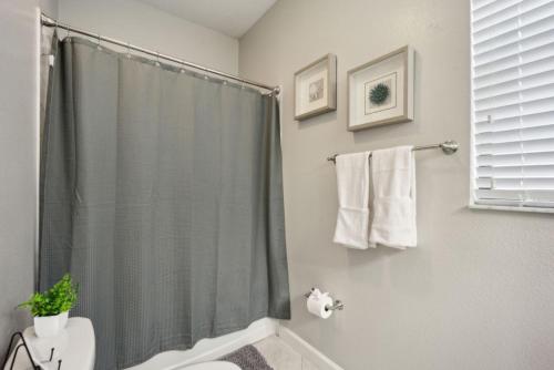a bathroom with a shower curtain and a toilet at Tampa Private Home Game Room Theater Room & more in Riverview