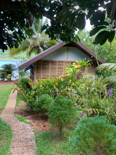 a small house in the middle of a garden at Pension TUPUNA in Haapu