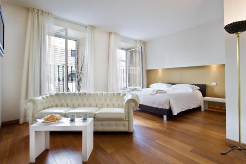 een slaapkamer met een bed, een bank en een tafel bij Relais Piazza Signoria in Florence