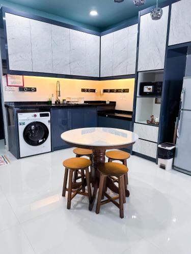 a kitchen with a table and two stools at Regency Tanjung Tuan - Idealhub in Port Dickson