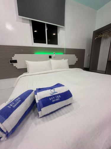 a bed with blue and white towels on it at Skyinn omadhoo in Omadhoo