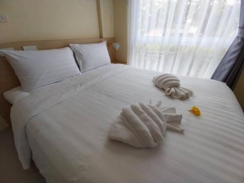 a white bed with towels on it with a window at Wellness World Chiva Khao Yai in Ban Wang Sai