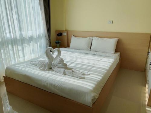 two swans sitting on a bed in a hotel room at Wellness World Chiva Khao Yai in Ban Wang Sai
