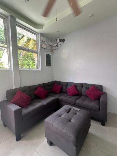 a living room with a gray couch and red pillows at Skyinn omadhoo in Omadhoo