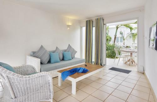 a living room with a couch and a table at Le Beachclub in Pereybere