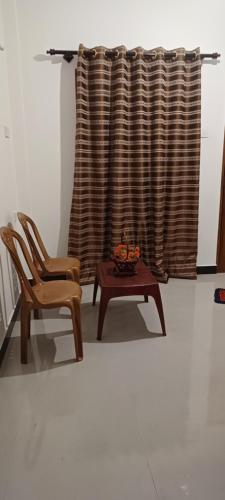a room with two chairs and a table and a curtain at Udawalawa Safari Lodge in Thenketiya