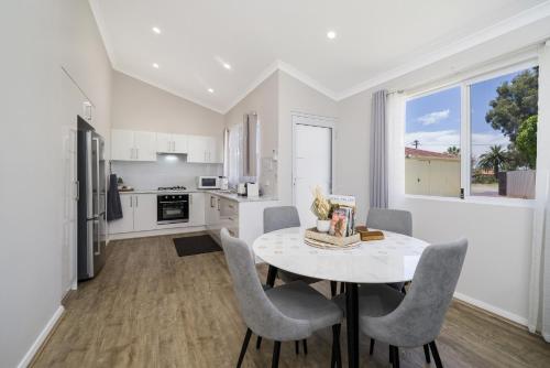 a kitchen and dining room with a table and chairs at Bright and Spacious 2-Bed Thornlie Family Home in Perth