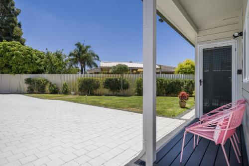a pink bench sitting on the porch of a house at Bright and Spacious 2-Bed Thornlie Family Home in Perth