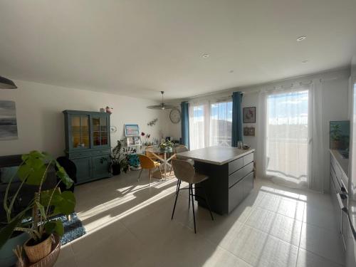 une cuisine et un salon avec une table et des chaises dans l'établissement T2 vue Pyrénées au Sud de Toulouse, à Toulouse