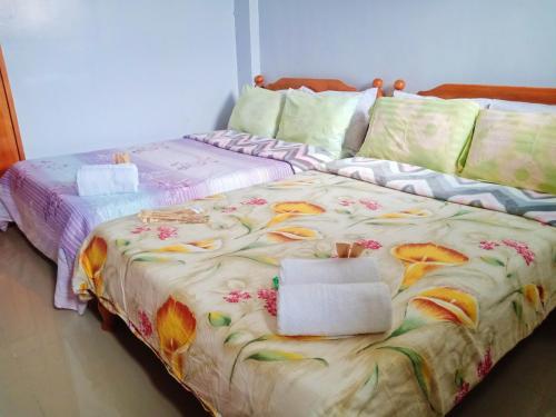 a bed with a blanket with flowers on it at SOLEIL de SAGADA INN in Sagada